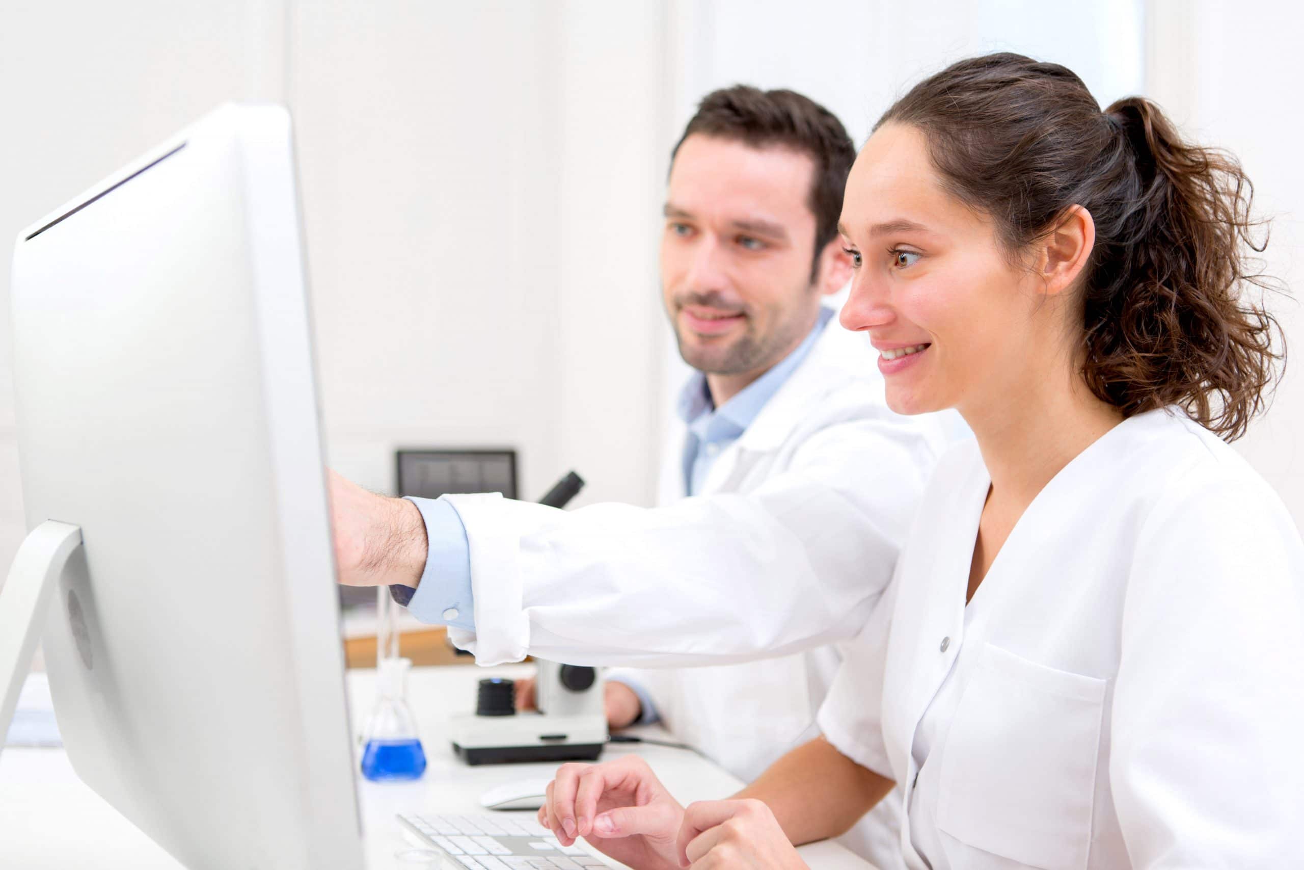 Pharmacist and Pharmacy Technician using a computer to learn together.