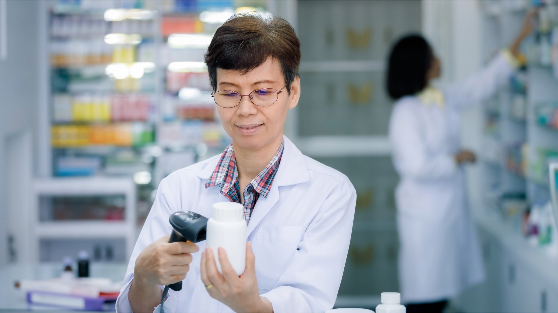 A pharmacy professional scans a medication stock bottle.