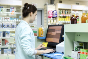 A pharmacy professional enter information into the pharmacy software program.